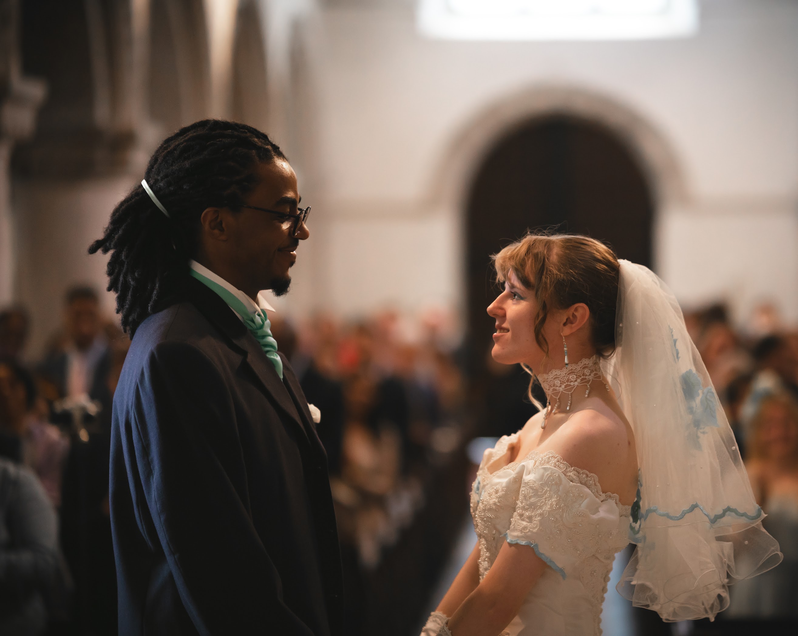 A photo from Andrew & Jade's wedding with them standing outside in front of the church